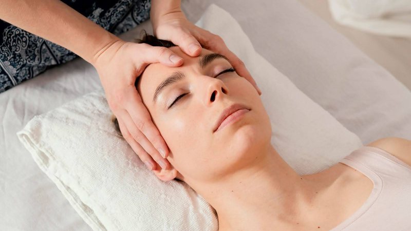 Mulher fazendo massagem facial - Reprodução/Freepik