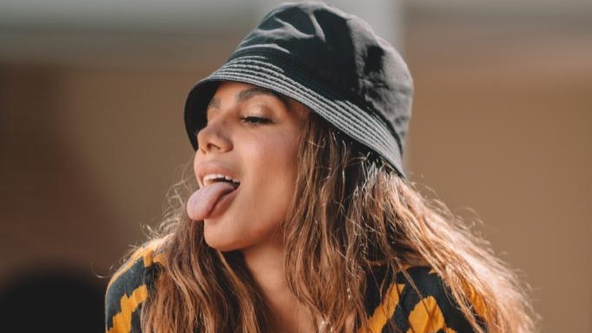 De roupão e look confortável, Anitta desembarca em São Paulo após férias na Europa
