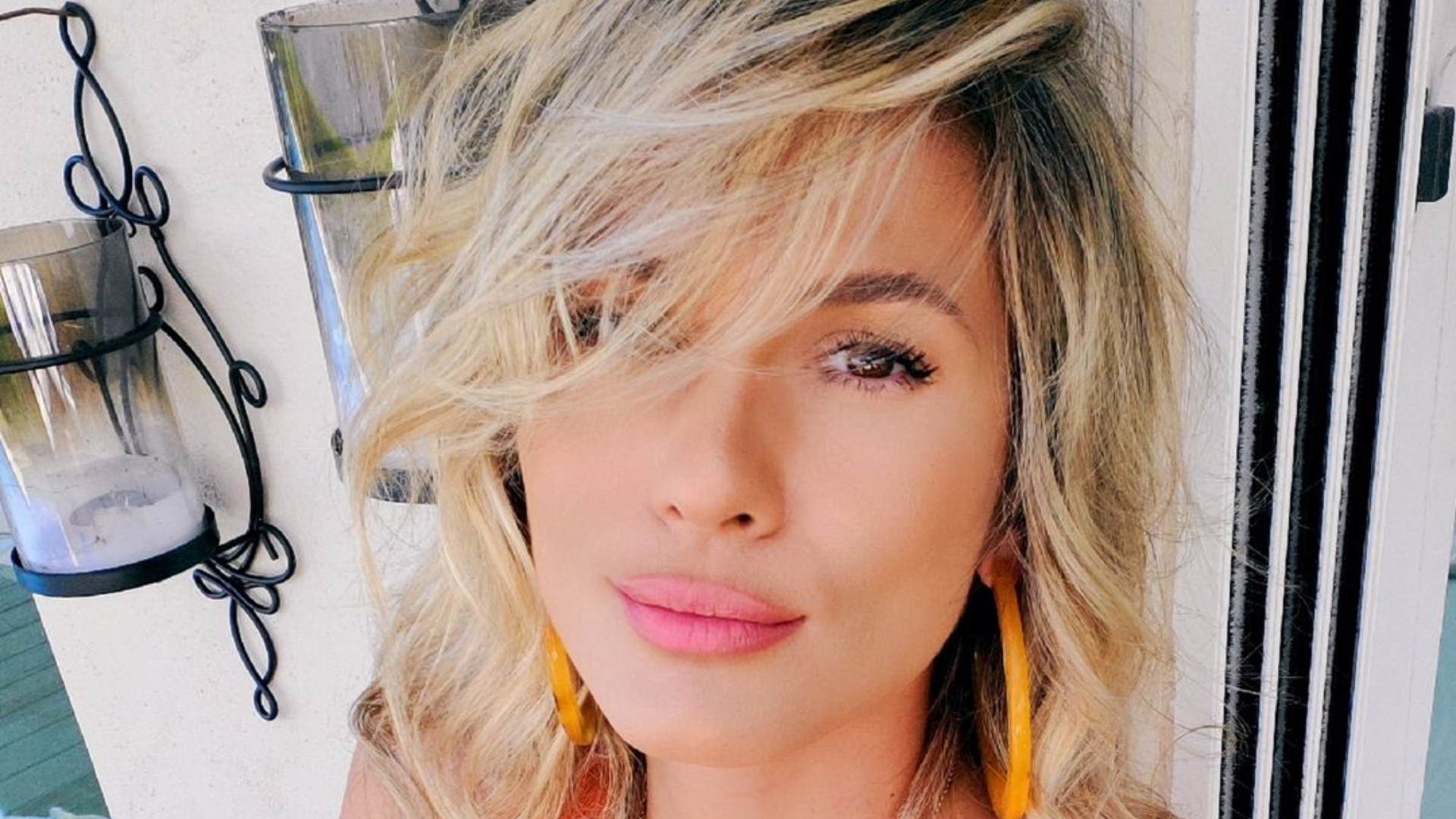Sentada na escada, Lívia Andrade faz pose enquanto renova seu bronze